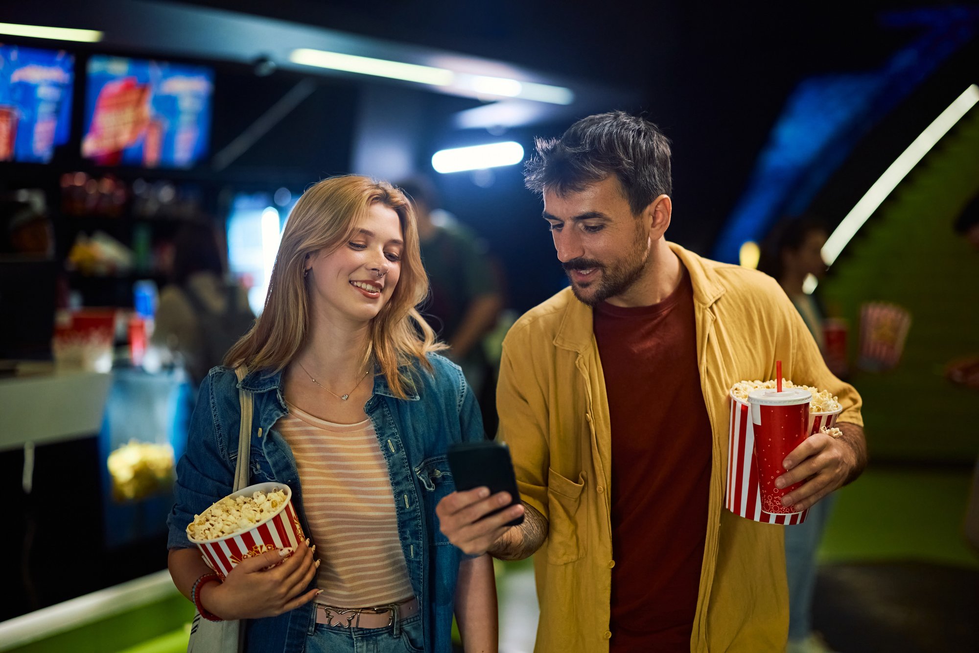 People at cinema looking at phone People at cinema looking at phone